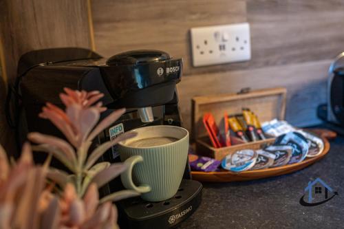 una macchinetta del caffè con una tazza di caffè su un bancone di Stanwick Studio, cosy country studio, sleeps 4, parking, wifi a Stanwick