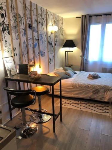 une chambre avec un lit, une table et un bureau dans l'établissement HSH FRANCE LOCATION Disney Land PARIS - Suite Nicolas - Appartement de charme, à Bussy-Saint-Georges