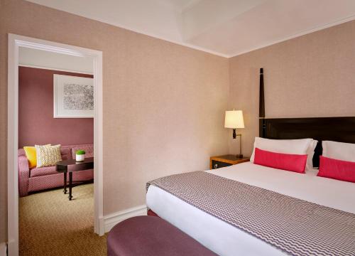 a hotel room with a bed and a chair at St. Ermin's Hotel, Autograph Collection in London