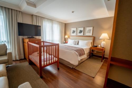 um quarto de hotel com uma cama e uma televisão de ecrã plano em George V Alto De Pinheiros em São Paulo