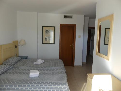 1 dormitorio con 1 cama con 2 toallas en PRECIOSO ÁTICO VISTAS MAR Y MARISMAS, en Isla Canela