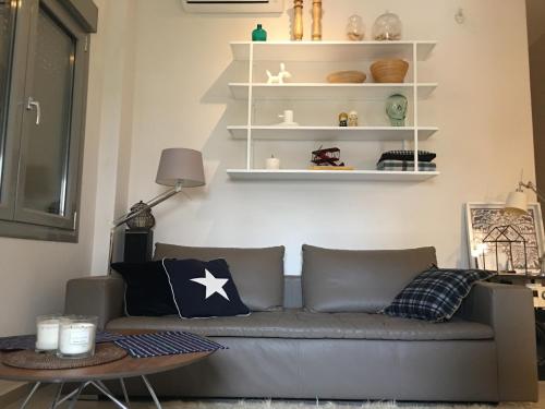 a living room with a gray couch and white shelves at Nikaia Metro House in Piraeus