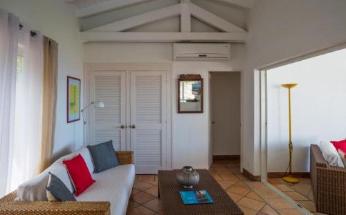 a living room with a couch and a table at Saint Barth Villa 15 in Pointe Milou