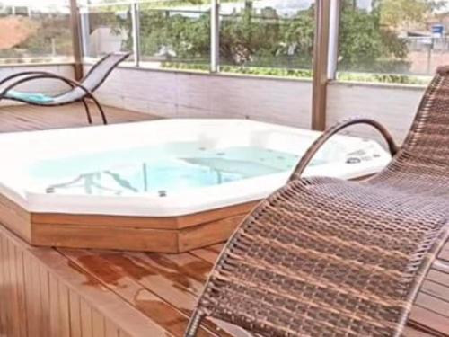 a jacuzzi tub in a room with two chairs at Espaço Lux Betim in Betim