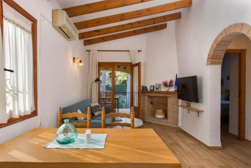 ein Wohnzimmer mit einem Holztisch und einem Wohnzimmer in der Unterkunft Apartamento en moraira con piscina in Moraira
