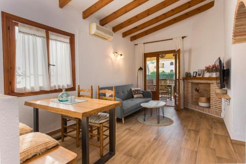 ein Wohnzimmer mit einem Tisch und einem Sofa in der Unterkunft Apartamento en moraira con piscina in Moraira