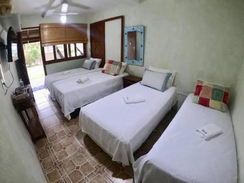 a room with two beds in a room at Green house in Praia do Rosa