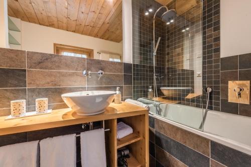 ein Badezimmer mit einem Waschbecken und einer Badewanne in der Unterkunft Le Mazot Alice in Vercorin
