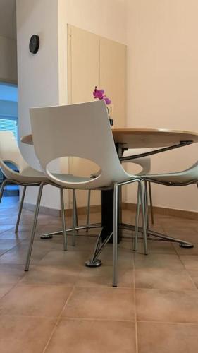 a table with two chairs and a table with a white chair at Sailing Apartment Lugano in Lugano