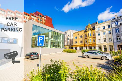 a parking lot with cars parked in front of a building at Hotel Koruna in Opava