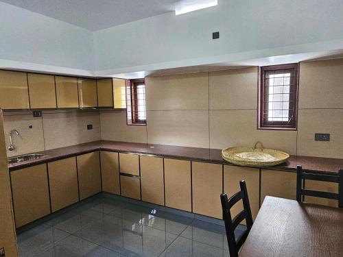 a large kitchen with a table and a counter top at MATHER RAJAGIRI FURNISHED APARTMENTS in Alwaye