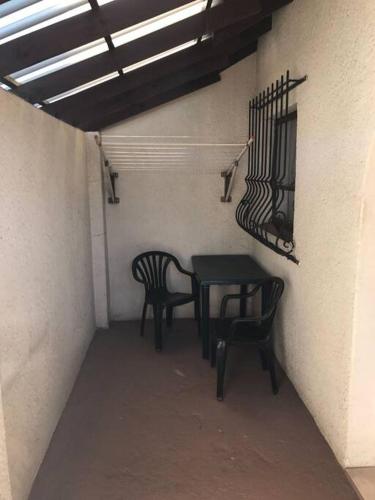 a patio with two chairs and a table and a balcony at The Royal Nest in Sandown