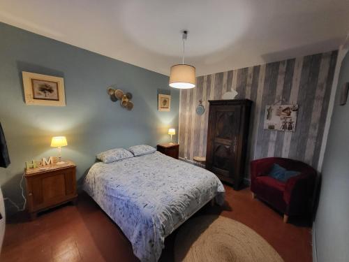 1 dormitorio con 1 cama y 1 silla roja en La maison du Perrin, en Gréez-sur-Roc
