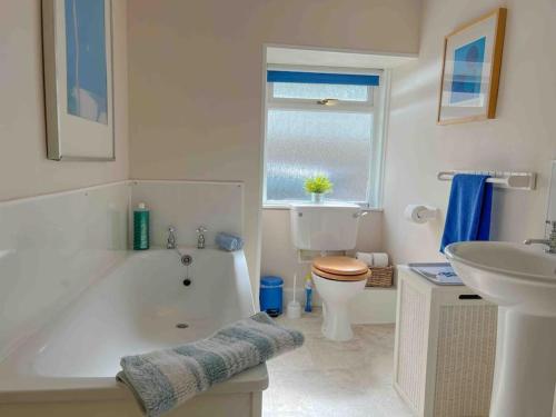 uma casa de banho com uma banheira, um WC e um lavatório. em Idyllic cosy bothy in remote beautiful surrounding em Amulree