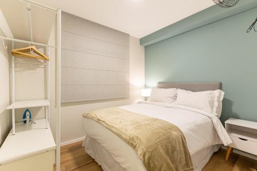 ein Schlafzimmer mit einem weißen Bett und einem Schrank in der Unterkunft BVB - Barra Funda - Anora Spaces Residenciais in São Paulo