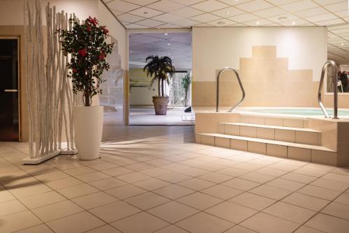 a lobby with a tub and flowers on the floor at Landgoed de Rosep in Oisterwijk