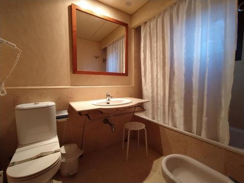 łazienka z umywalką, toaletą i lustrem w obiekcie DOS DORMITORIOS CON TRES TERRAZAS EN CUARTA PLANTa w mieście Isla Canela