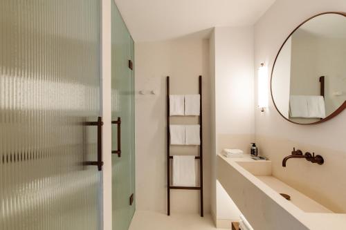 a bathroom with a shower and a sink and a mirror at The Standard, Ibiza in Ibiza Town