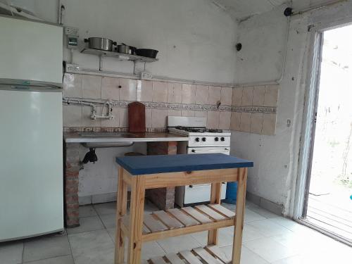 uma cozinha com um fogão e uma mesa em Los Aloes, Casa de campo em Las Toninas