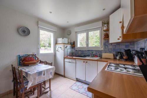 une cuisine avec un réfrigérateur blanc et une table dans l'établissement Emji - Maison proche de la plage, à Ver-sur-Mer