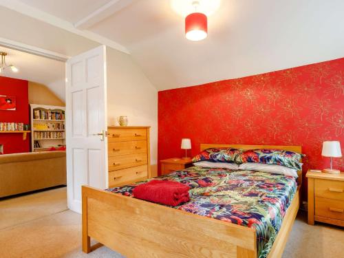 um quarto com uma cama e uma parede vermelha em 1 Bed in Ashford-in-the-Water 87471 em Great Longstone