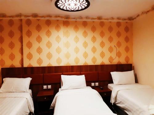 a room with two beds and a wall at فندق انوار المشاعرالفندقية in Makkah