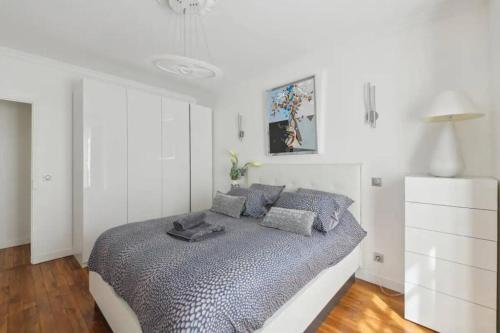 une chambre avec un lit dans une pièce blanche dans l'établissement Luxe à la francaise 75017, à Paris