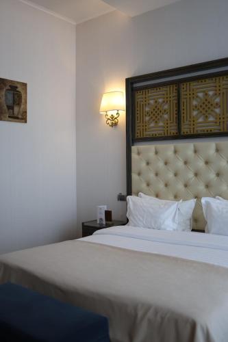 a bedroom with a large bed with a large headboard at KADORR Hotel Resort & Spa in Odesa