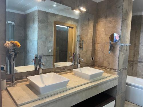 baño con 2 lavabos y espejo grande en Altos de Finestrat, en Finestrat