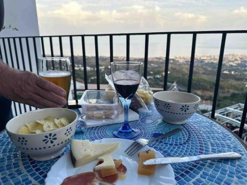 una mesa con una copa de vino y un plato de comida en Precioso apartamento con vistas en Mijas
