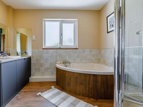 baño con bañera y ventana en 4 bed in Bude 88299, en Bude