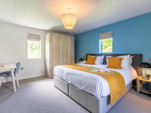 a bedroom with a large bed with blue walls at 2 Bed in St. Mellion 87710 in St Mellion