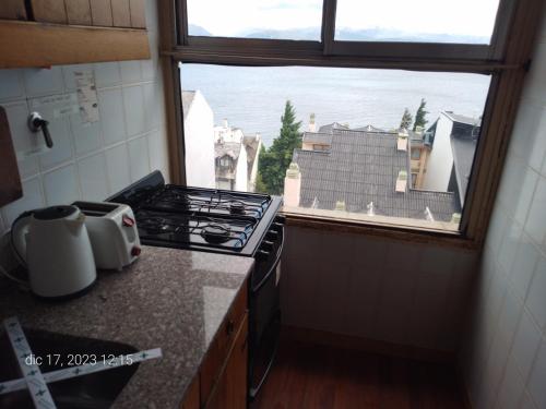 a kitchen with a stove top oven next to a window at Lo de Ramón in San Carlos de Bariloche