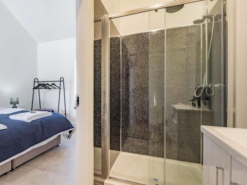 La salle de bains est pourvue d'une douche en verre et d'un lit. dans l'établissement 2 bed in Caernarfon 88043, à Caernarfon
