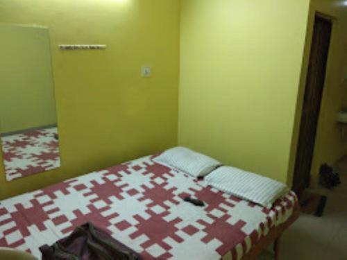 a bedroom with a bed with a red and white quilt at Hotel Crystal,Bhubaneswar in Bhubaneshwar