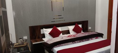a bedroom with a bed with red and white pillows at Shree Gorakhnath Guest House in Ayodhya
