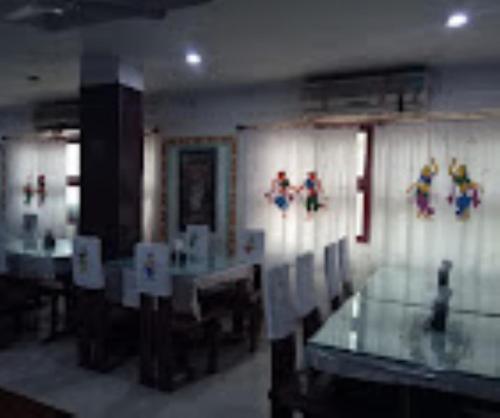 a dining room with tables and figurines on the wall at Hotel Rajdhani Roxy,Bhubaneswar in Bhubaneshwar
