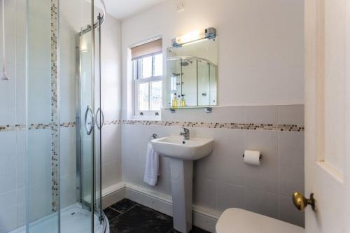 a bathroom with a sink and a glass shower at The Dairy in Hartland