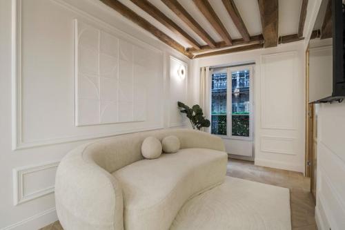 un salon avec un canapé et une fenêtre dans l'établissement Suite Royale # Palais de l'Elysée # Paris 8, à Paris