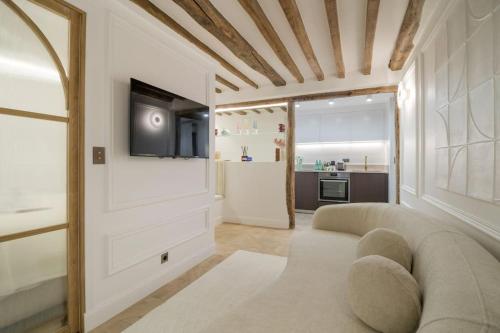 un salon avec un canapé et une télévision dans l'établissement Suite Royale # Palais de l'Elysée # Paris 8, à Paris