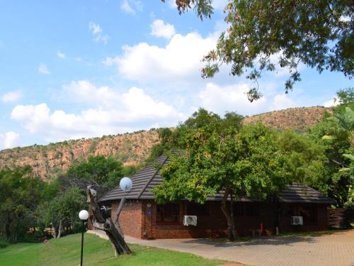 a building with a tree in front of it at Mount Amanzi in Hartbeespoort