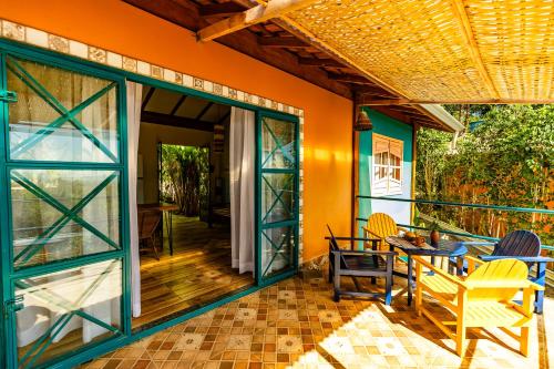 a patio with glass doors and a table and chairs at Casa Papaya in Santa Cruz Cabrália