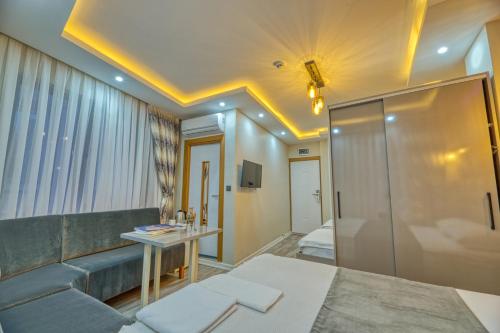 salon z kanapą i łóżkiem w pokoju w obiekcie GALATAGREENAPPLEHOTEL w Stambule