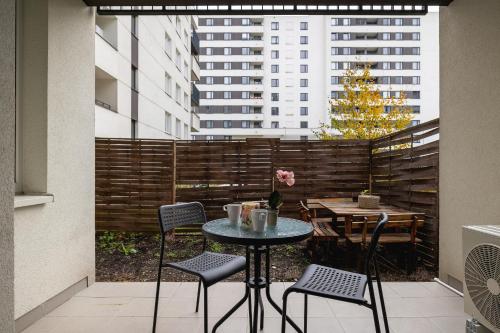 a patio with a table and chairs on a balcony at Cracow Royal Blue Apartment Avia Estate by Renters in Kraków