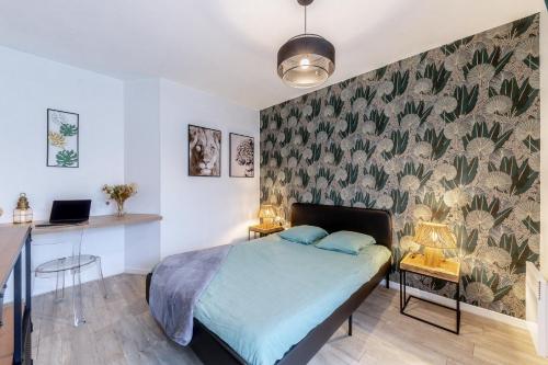 a bedroom with a bed and a desk with a laptop at Charmant et fonctionnel in Talence