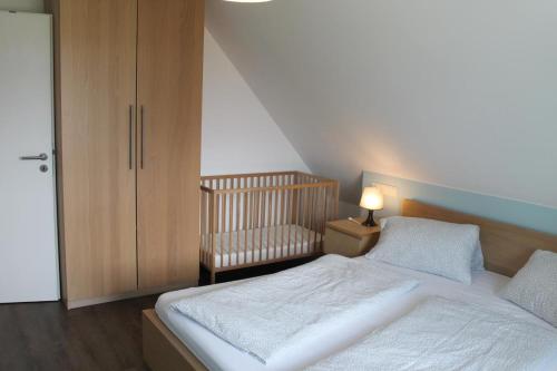 a small bedroom with a bed and a crib at Ferienhaus De niege Leive in Born