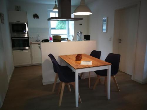 a kitchen with a wooden table and chairs in a kitchen at Ferienwohnung Art in Born in Born