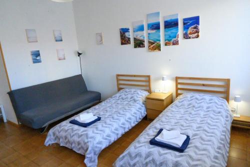 2 camas y un sofá en una habitación en Appartamento Cialdini Centro Ancona, en Ancona