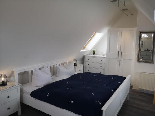 - une chambre avec un lit et une couette bleue dans l'établissement FeWo Namenlos gemuetliche FeWo fuer 3 Personen mit Balkon, à Born