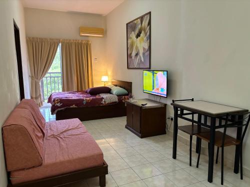 un soggiorno con letto, divano e TV di Sofea Inn Bukit Merah - Suria A7245 a Simpang Ampat Semanggol